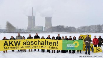 Green politicians holding protest sign in front of Grafenrheinfeld nuclear plant (Photo: David Ebener/dpa)